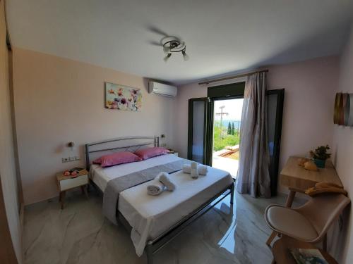 Schlafzimmer mit einem Bett mit rosa Kissen und einem Fenster in der Unterkunft Freesia Grand Sea View Residence in Sarláta