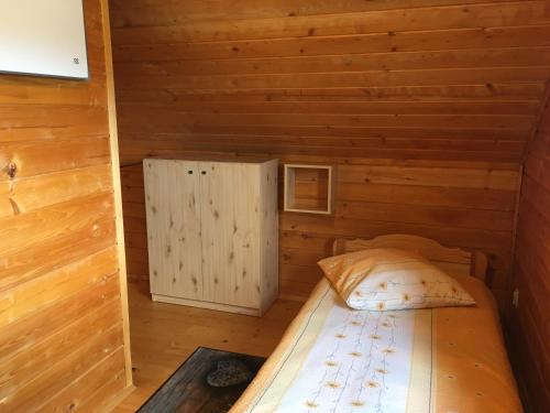 a room with a bed in a log cabin at Filkówka- Słoneczne Wzgórze in Wadowice