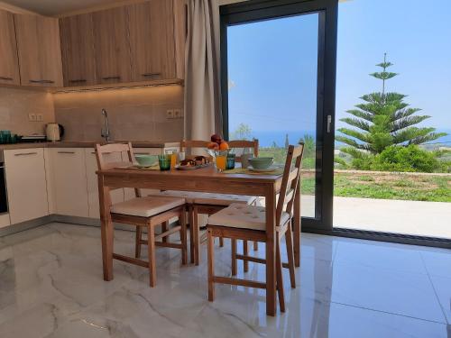 a kitchen with a table and chairs and a large window at Freesia Grand Sea View Residence in Sarlata