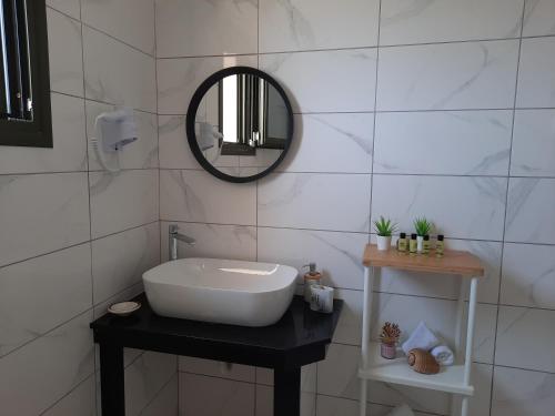 a white bathroom with a sink and a mirror at Freesia Grand Sea View Residence in Sarlata