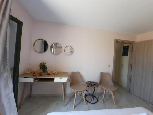 a room with two chairs and a table and mirrors at Freesia Grand Sea View Residence in Sarlata