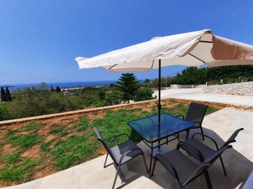 a table and two chairs under an umbrella at Freesia Grand Sea View Residence in Sarlata