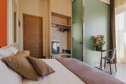 a bedroom with a bed and a table with a vase of flowers at Hotel 33 Baroni in Gallipoli