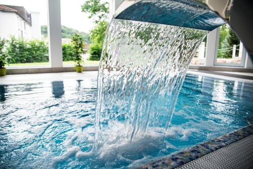 a fountain in the middle of a swimming pool at Hotel Villa Elsa in Bad Kissingen