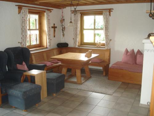 uma sala de jantar com mesa, cadeiras e janelas em Ferienwohnung Peschl Langdorf Bayerischer Wald em Langdorf