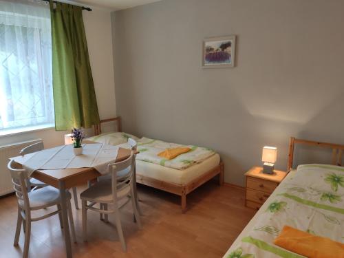Zimmer mit 2 Betten, einem Tisch und einem Bett in der Unterkunft Ubytovanie na Frantšachte in Banská Štiavnica