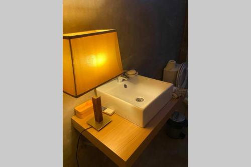 a bathroom with a white sink on a wooden table at Made iN2 Creative Guest House in Montargil