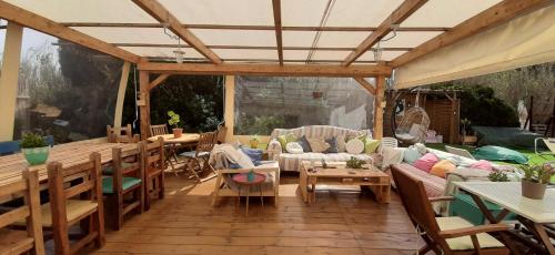 an outdoor patio with a couch and chairs and tables at Blacksheep Sagres Guesthouse & Surf in Sagres