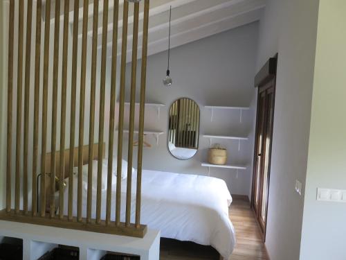 sypialnia z białym łóżkiem i lustrem w obiekcie LA CASINA DEL OLIVO w mieście Ribadesella