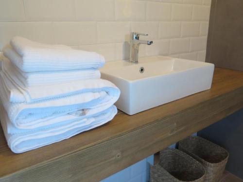a pile of towels sitting on a counter next to a sink at LA CASINA DEL OLIVO in Ribadesella