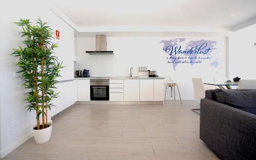 a living room with a couch and a kitchen at Paradise Quarteira in Quarteira