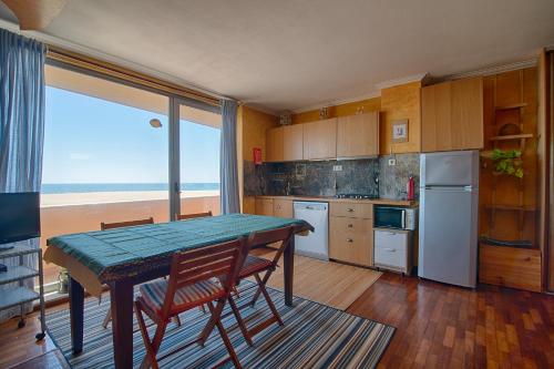 a kitchen with a table and chairs and a window at House In Aguda Beach, praia da Aguda, in Aguda