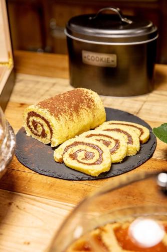 two pastries on a plate on a table with a slow cooker at Agr. Cascina Fabbrica in Fossano