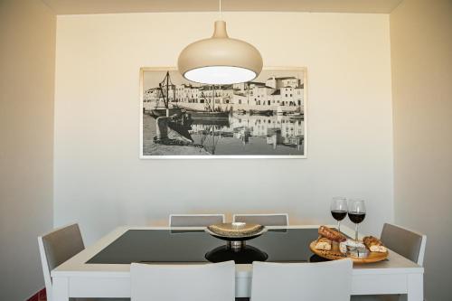 een eetkamer met een tafel met wijnglazen en een foto bij SEASHORE in Peniche