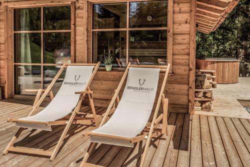 twee stoelen op een terras voor een cabine bij Benglerwald Berg Chaletdorf in Bach