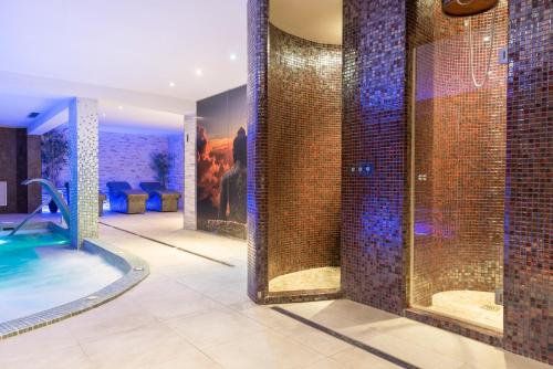 a bathroom with a swimming pool and a room with at Hotel Torre Azul & Spa - Adults Only in El Arenal