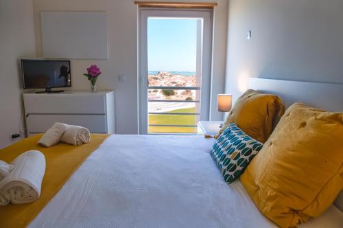 een slaapkamer met een groot bed en een groot raam bij SEASHORE in Peniche