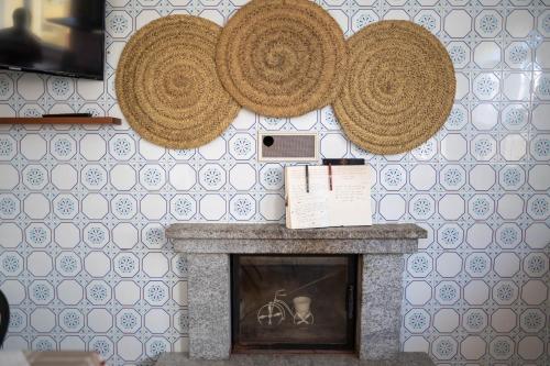 a fireplace with two straw hats on the wall at Pensión Casa do Gallo Sarria in Sarria