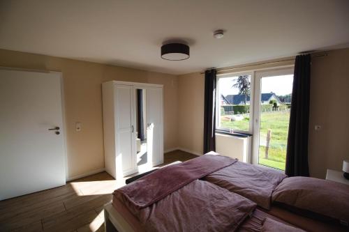 una camera con un grande letto e una grande finestra di eifelbleibe a Monschau