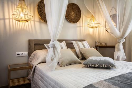 a bedroom with a white bed with curtains and pillows at Bella Casa in Stalida