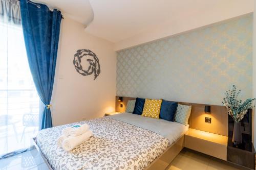 a bedroom with a bed with blue curtains at Light House - Seafront cosy studio with library in Paphos City