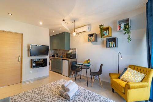 a living room with a yellow couch and a kitchen at Light House - Seafront cosy studio with library in Paphos City