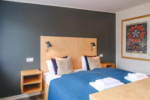 a bedroom with a large bed with a blue blanket at Hotel Aldan - The Post Office in Seyðisfjörður