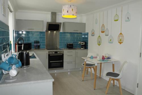 una cocina con armarios blancos y azulejos azules en BONNIE'S APARTMENT, adults only, en Bowness-on-Windermere