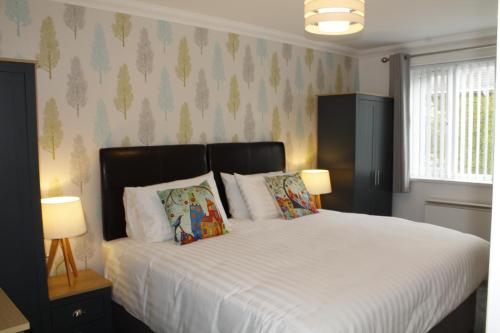 a bedroom with a large white bed with two lamps at BONNIE'S APARTMENT, adults only in Bowness-on-Windermere