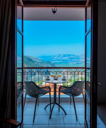 a table and chairs on a balcony with a view at Fedriades Delphi Hotel in Delfoi