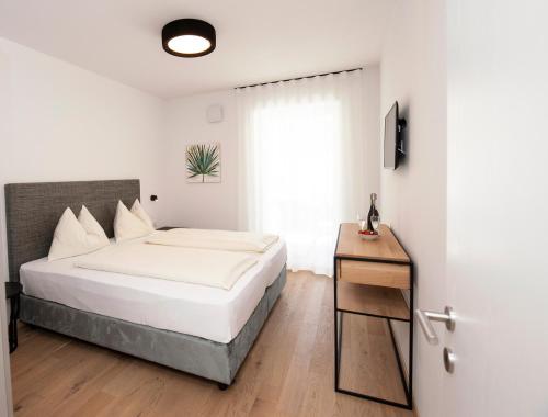 a white bedroom with a bed and a window at Modern Living by Nalserhof in Nalles