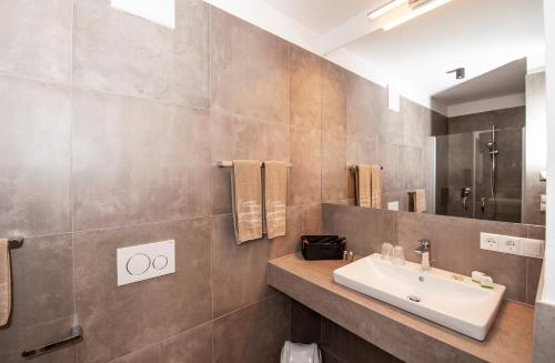 a bathroom with a sink and a mirror at Modern Living by Nalserhof in Nalles