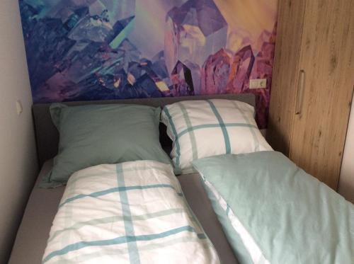 Fewo Eifeler Edelsteine „Aquamarin“ في شليدن: سرير مع وسادتين في غرفة