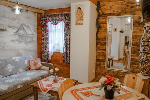 ein Wohnzimmer mit einem Sofa und einem Tisch in der Unterkunft Willa Mnich in Bukowina Tatrzańska