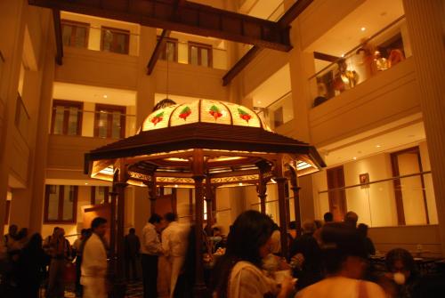 a group of people standing around a carousel in a building at The Lalit Great Eastern Kolkata in Kolkata