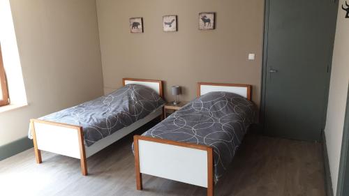 two twin beds in a room with two mirrors at Au Pied du Gazon in Saint-Maurice-sur-Moselle