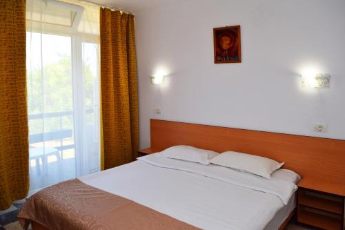 a bedroom with a bed and a large window at Hotel Sanda in Venus