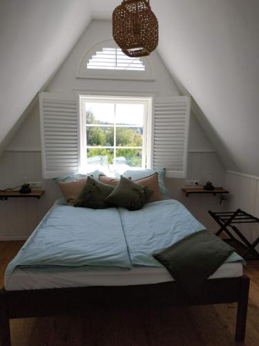 a bedroom with a large bed with a window at Ferienwohnung Kleiner Onkel in Uhldingen-Mühlhofen