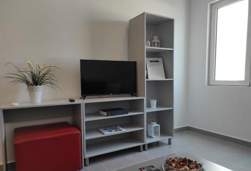 a living room with a television on a shelf at Milva Apartments in Kos Town