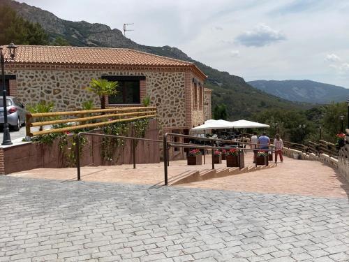 a stone building with people standing outside of it at Hotel Rural La Cabrera in Robledo del Buey