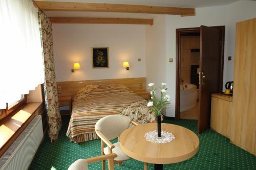 a hotel room with a bed and a table and chairs at Chata Panorama Beskidów in Ustroń