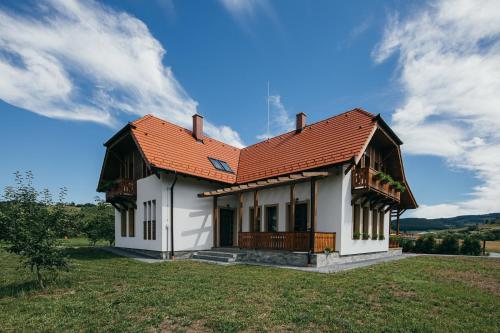 una casa blanca con techo naranja en un campo en Hygge Praid, en Praid