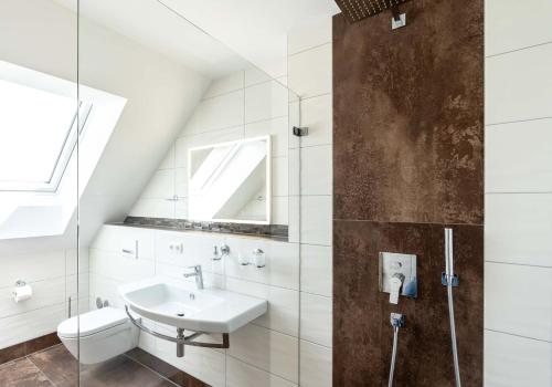 a bathroom with a sink and a toilet at Gästehaus Lemerhof in Oberding