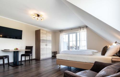 um quarto com uma cama, uma secretária e uma mesa em Gästehaus Lemerhof em Oberding