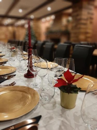 a table with wine glasses and a red flower on it at Hotel Rural La Cabrera in Robledo del Buey