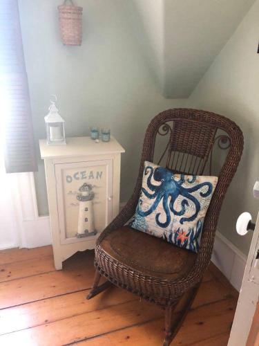 a wicker chair with a pillow in a room at Fisherman's Daughter B&B in Mahone Bay