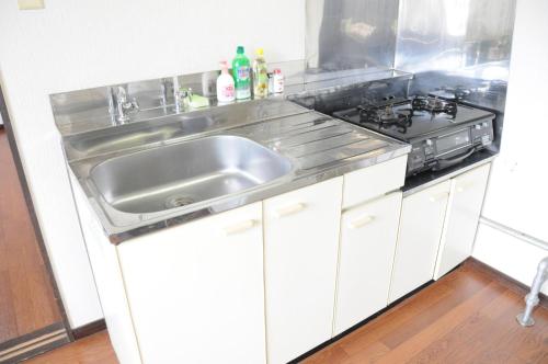 una cucina con lavandino e piano cottura di Ark City Asahikawa - Vacation STAY 8525 a Asahikawa