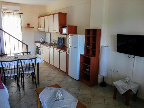 a kitchen with a table and a white refrigerator at Dasea Houses in Ormos Panagias
