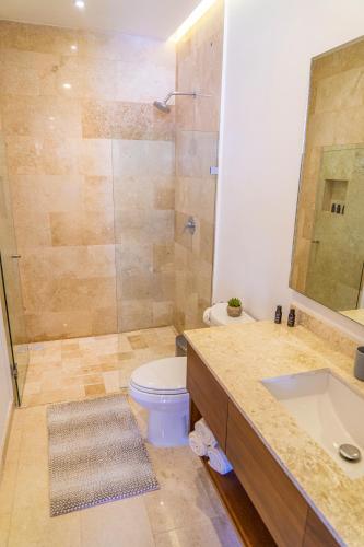 a bathroom with a shower and a toilet and a sink at Tres Marias Luxury Suites - Adults Only in Puerto Vallarta