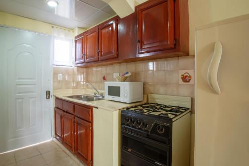 a small kitchen with a stove and a microwave at Hotel Plaza Europa in Sosúa